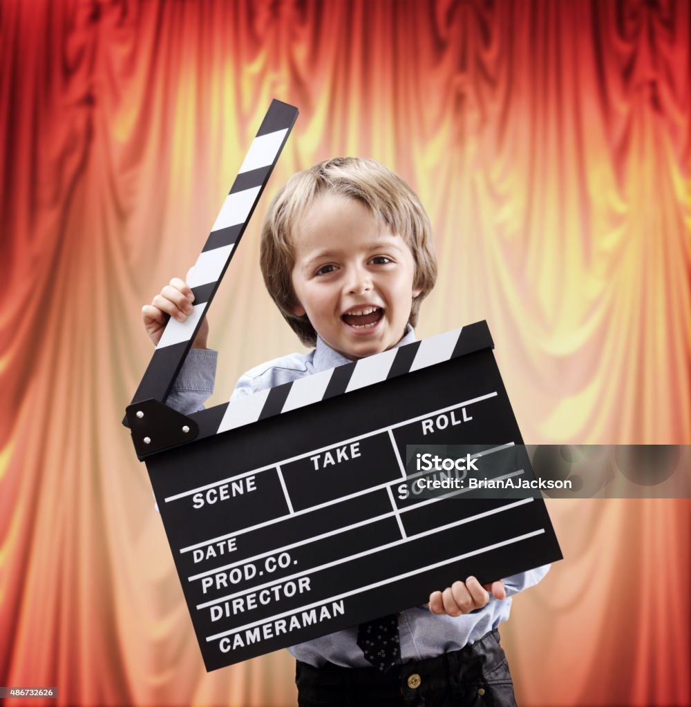 Un garçon tenant clapper conseil d'administration dans un théâtre cinéma - Photo de Enfant libre de droits