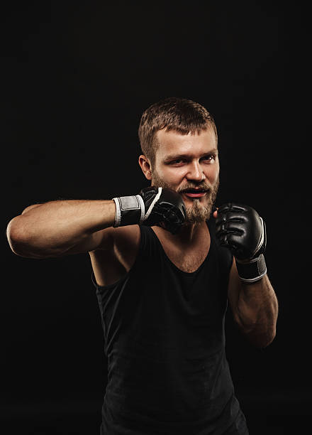 istock Athletic bearded boxer with gloves on a dark background 486732778