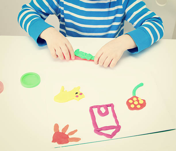 istock little boy playing with clay dough, education and daycare 486737134
