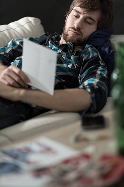 Sad man lying Young sad and depressed man lying on the sofa ex girlfriend stock pictures, royalty-free photos & images