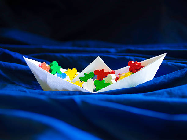 istock Immigration emigration migration concept, paperboat with meeples 486742352