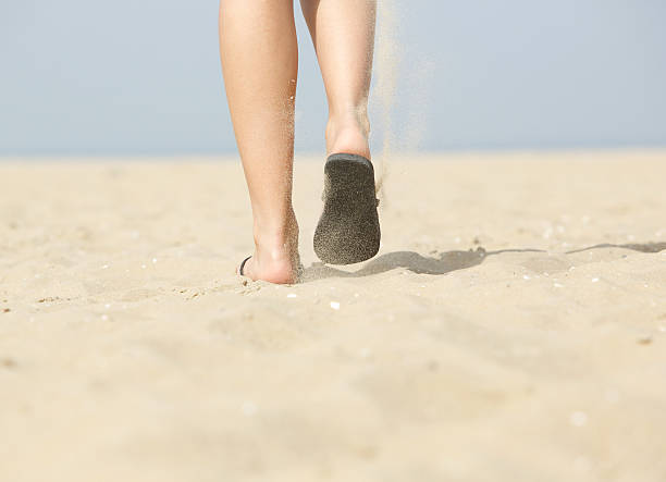 女性の砂のビーチを歩くにスリッパ - flip flop human foot sand women ストックフォトと画像