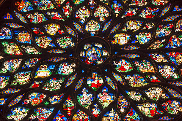 Jesus Christ Rose Window Stained Glass Sainte Chapelle Paris France Jesus Christ With Sword Surrounded by Biblical and Medieval Stories Angels, Mary Rose Window Stained Glass Saint Chapelle Paris France.  Saint King Louis 9th created Sainte Chappel in 1248 to house Christian relics, including Christ's Crown of Thorns.  Stained Glass created in the 13th Century and shows various biblical stories along wtih stories from 1200s. sainte chapelle stock pictures, royalty-free photos & images