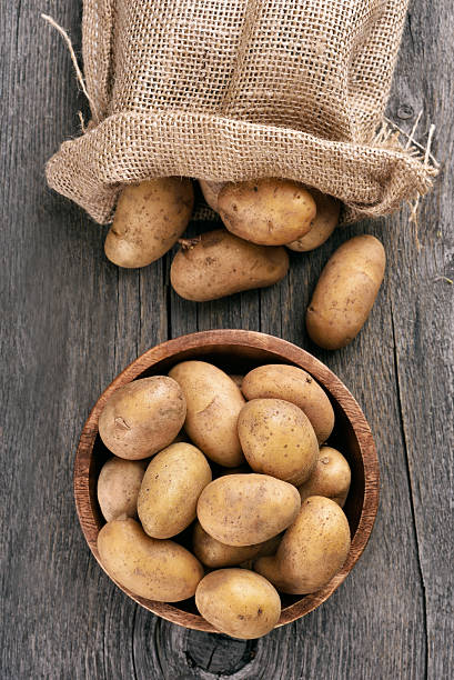 fruits sur une table en bois de pommes de terre - raw potato organic rustic bag photos et images de collection