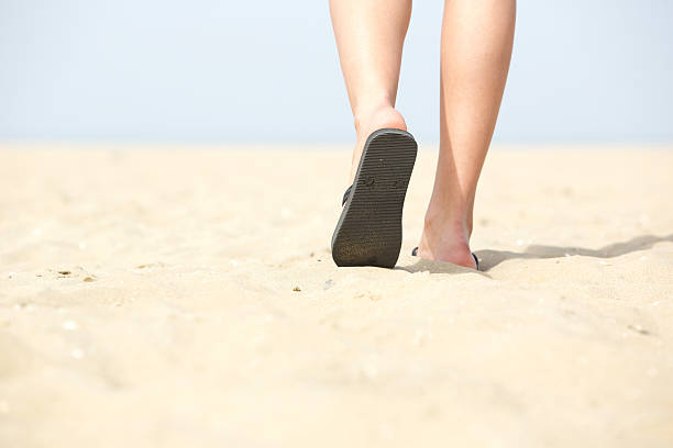 istock Sandals walking on sand at the beach 486744431
