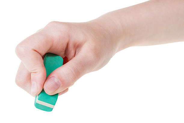 hand with new green rubber eraser close up isolated on white background