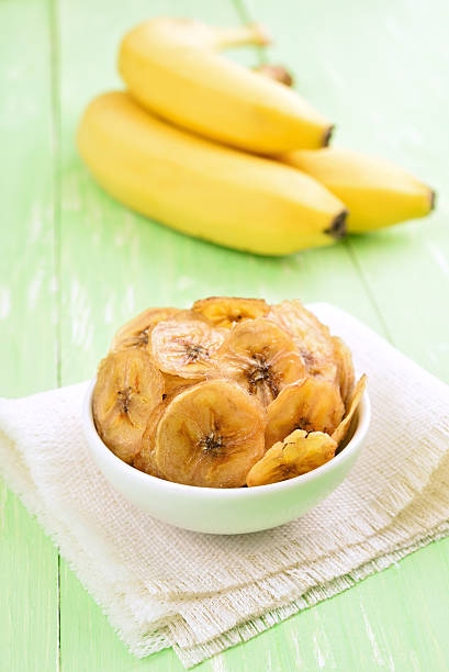 istock Banana chips in bowl and fresh bananas 486747420