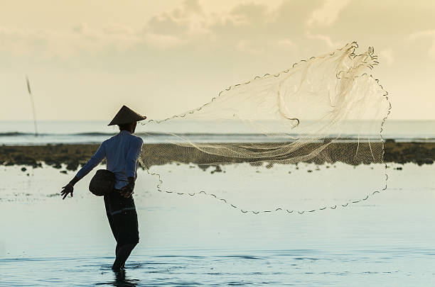 istock Asian fisherman throwing his fish net 486748227