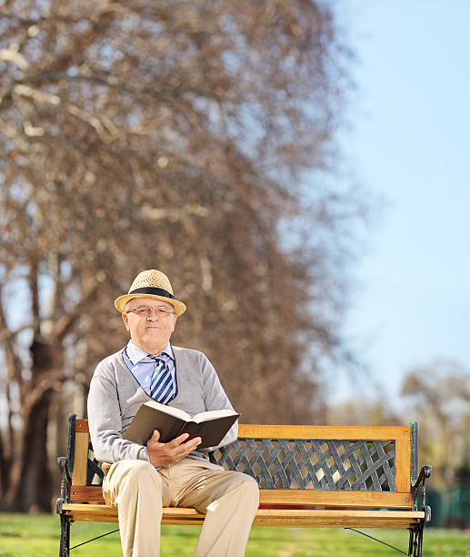 istock Senior gentleman reading a book in park 486749769