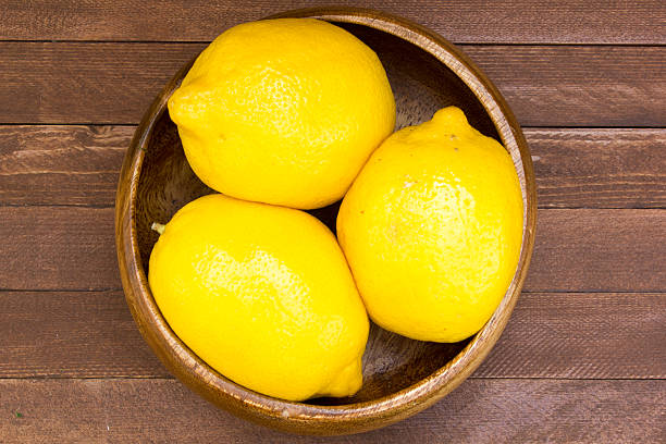 istock Lemons in plate on wooden background 486758230