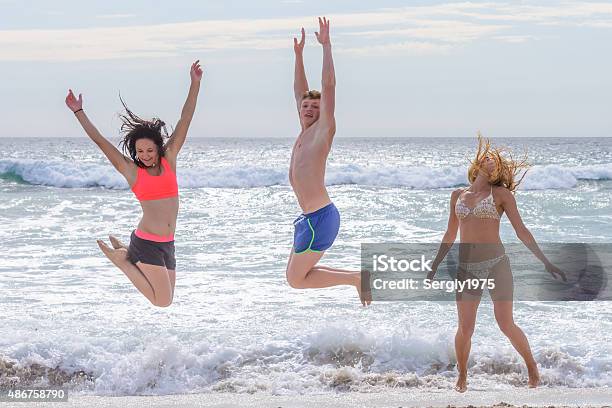 Young Men Jumping On The Beach Stock Photo - Download Image Now - 2015, Active Lifestyle, Activity