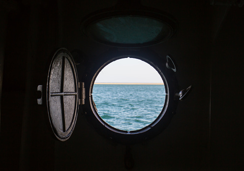ship porthole on wooden wall on the boat