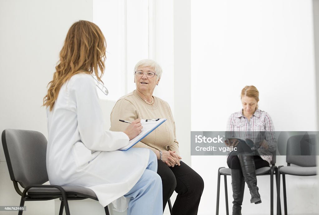 Médecin parler aux patients dans une salle d'attente. - Photo de Adulte libre de droits