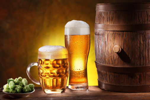 Beer glasses with a wooden barrel. Background - dark yellow gradient.