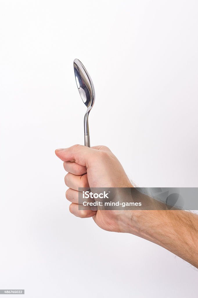 Hand is holding a spoon isolated Hand is holding a spoon isolated on a white background 2015 Stock Photo