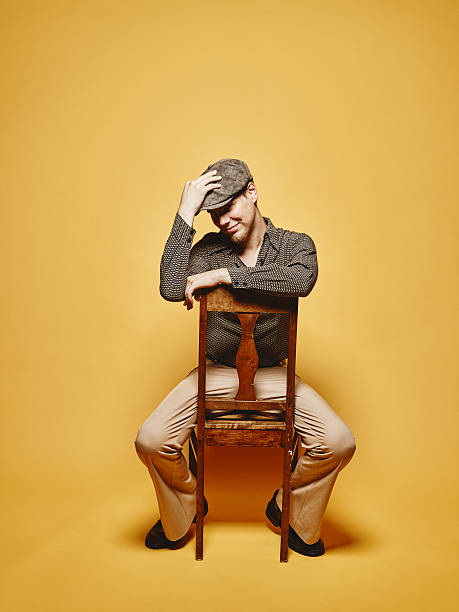 istock Expressive man sits on the chair and 70's look theme 486766364