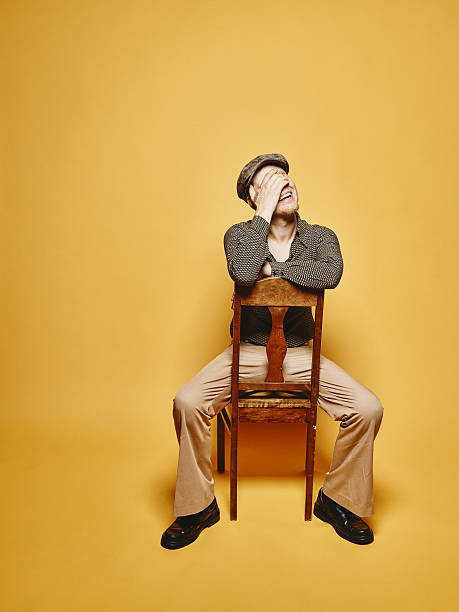 istock Expressive man sits on the chair and 70's look theme 486766694