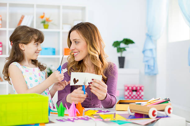 istock Mother and daughter making origami. 486766831