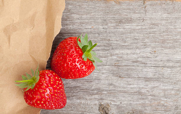 istock Ripe strawberries over wooden table background 486768609