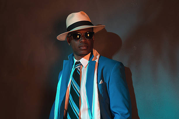istock African american retro man in blue suit wearing straw hat. 486777356