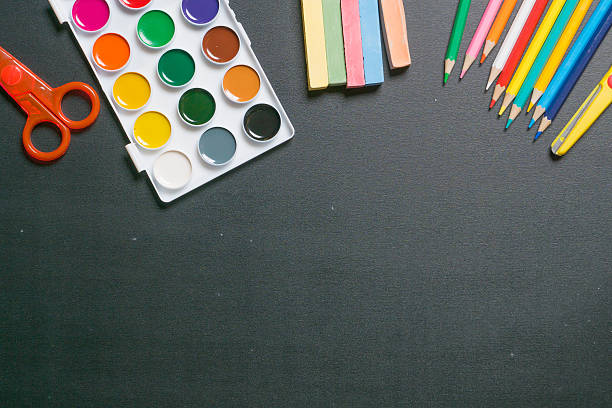 istock paints, scissors, pencils and chulks on black chalkboard 1 486778430