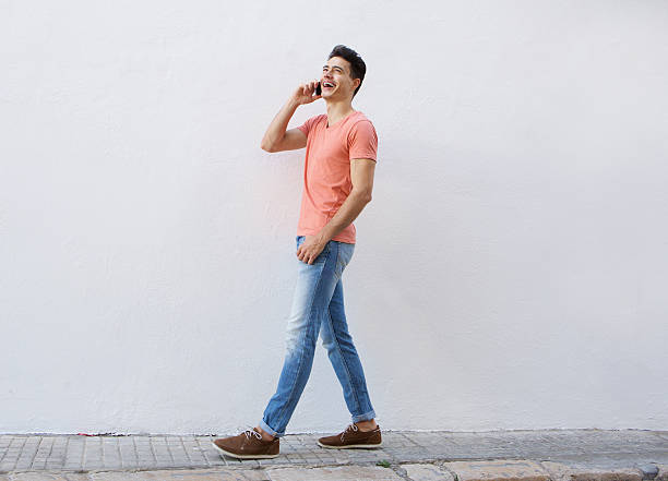 istock Smiling man walking and listening to mobile phone 486779556