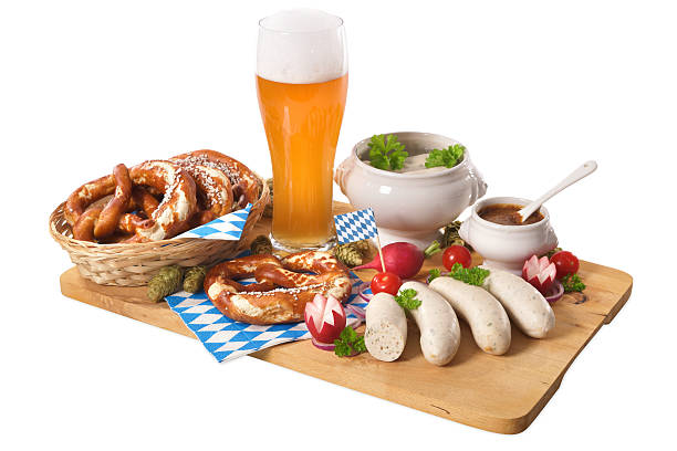 Bavarian veal sausage breakfast Bavarian veal sausage breakfast with sausages, soft pretzel, wheat beer and mild mustard on wooden board from Germany weisswurst photos stock pictures, royalty-free photos & images