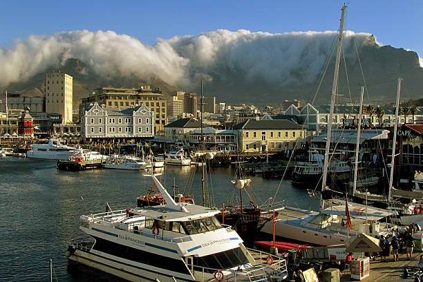 Waterfront in Cape Town with Table Mountain Waterfront in Cape Town with Table Mountain. The cloud deck over the mountain (the so called table cloth) is falling down. table mountain and the tablecloth stock pictures, royalty-free photos & images