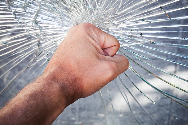 Powerful male fist with broken glass Powerful male fist with broken window glass fist human hand punching power stock pictures, royalty-free photos & images