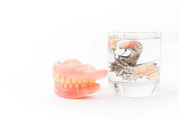 istock denture is cleaned in a glass of water. proper hygiene. 486784286