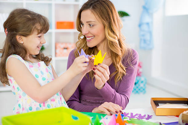 istock Mother and daughter making origami. 486785525