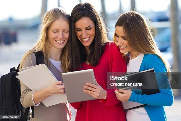 Students Having Fun With Smartphones And Tablets After Class Stock Photo - Download Image Now