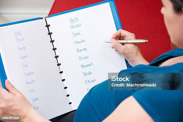 Pregnant Mother Choosing Name For Unborn Baby Stock Photo - Download Image Now - Identity, Book, List