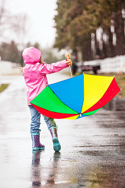 istock Girl Dancing in the Rain with Umbrella 486788119