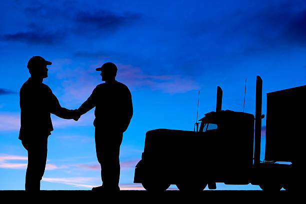 istock Silhouette of two truck drivers shaking hands 486789273