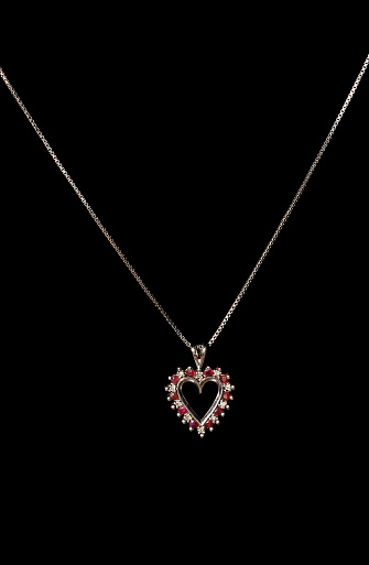 Beautiful silver heart necklace pendant with red rubies on a thin silver chain.