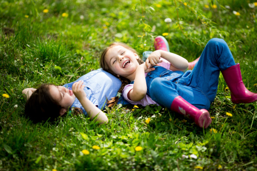 Two little girls make shape of heart with hands