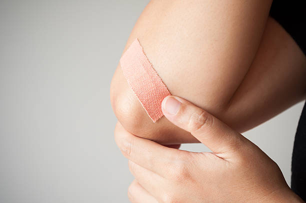 Elbow with adhesive bandage stock photo
