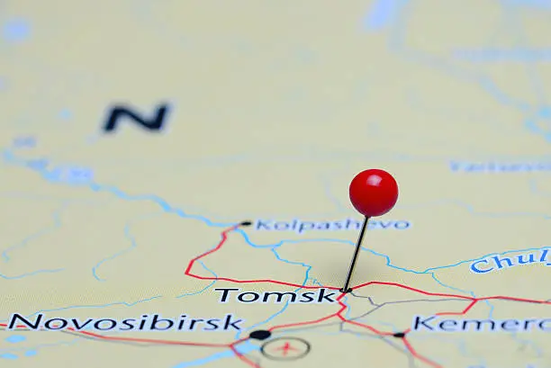 Photo of pinned Tomsk on a map of Asia. May be used as illustration for traveling theme.