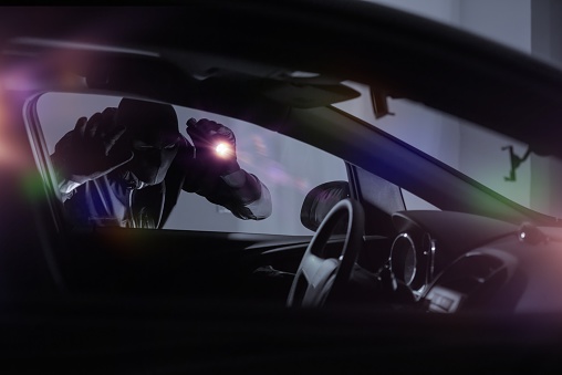 Ladrón de coche con linterna photo