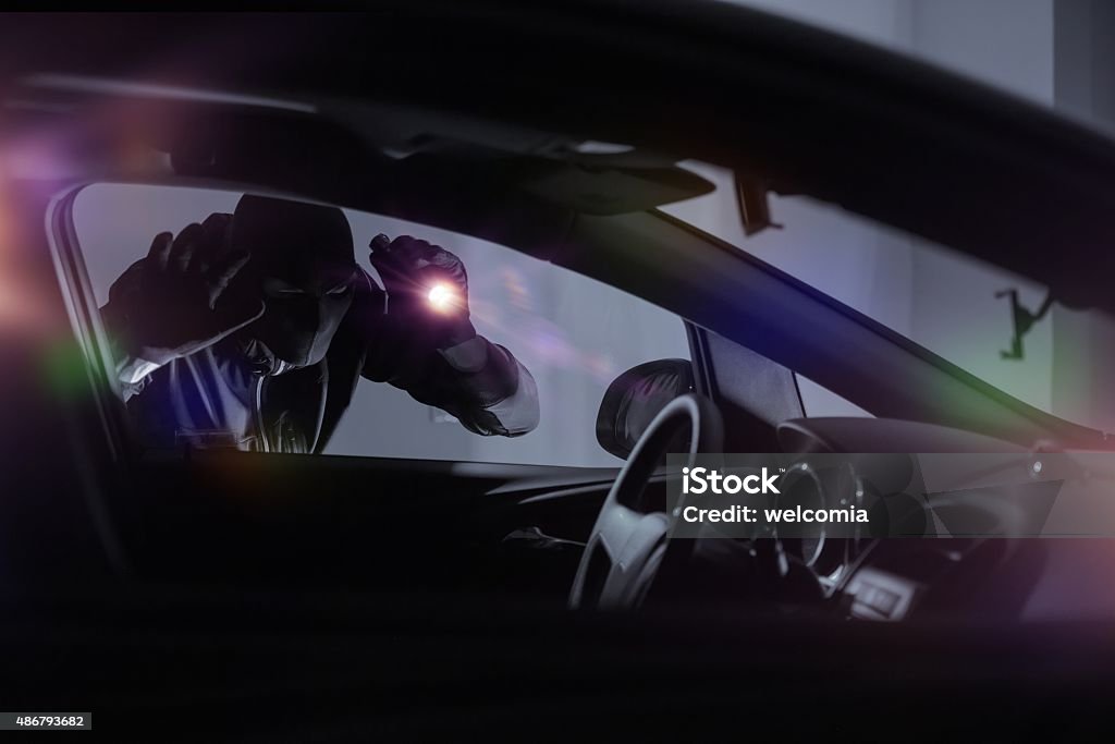 Car Robber with Flashlight Car Robber with Flashlight Looking Inside the Car. Car Security Theme. Car Stock Photo