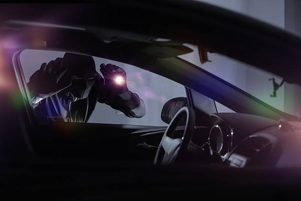 Car Robber with Flashlight Car Robber with Flashlight Looking Inside the Car. Car Security Theme. thief stock pictures, royalty-free photos & images