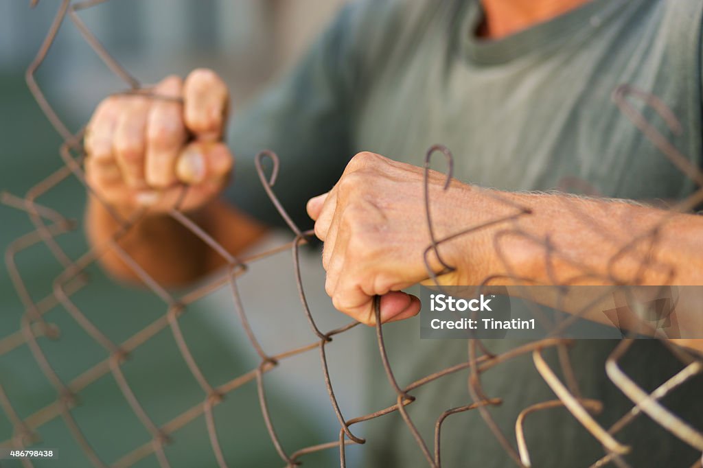 Breaking down the fence A man breaking down the fence. Immigration concept 2015 Stock Photo