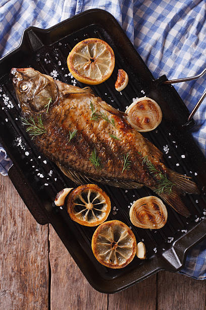 istock Grilled carp with lemon in grill pan vertical top view 486798658
