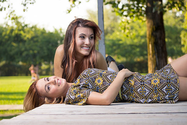 istock Two beautiful girls lying on wooden boards. 486799990