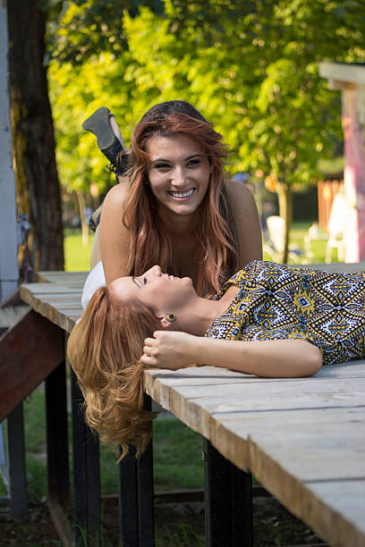 istock Two beautiful girls lying on wooden boards. 486800536