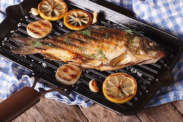 istock grilled fish carp with lemon  on frying pan grill, horizontal 486800652