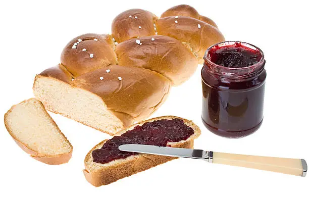 Wheat bread slice (yeast braid) smeared with cherry jam and honey