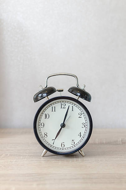 istock modern black alarm clock on wooden table 486806808