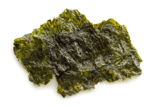 A sheet of Nori also known as Gim, Laver and Zicai (Edible seaweed) commonly used to make sushi on a white background.